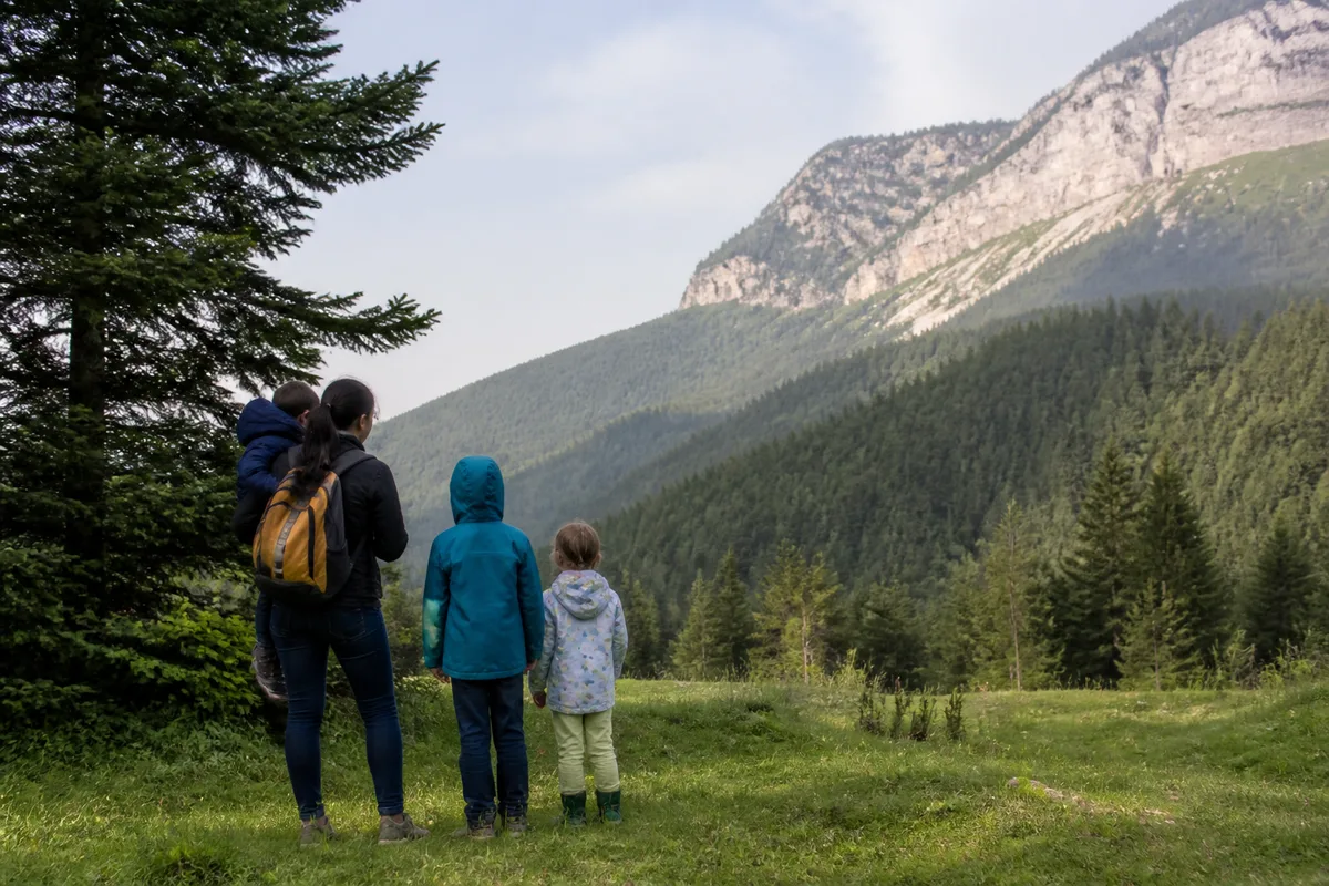 Famille observant une clairière et les reliefs du Vercors pendant une balade nature